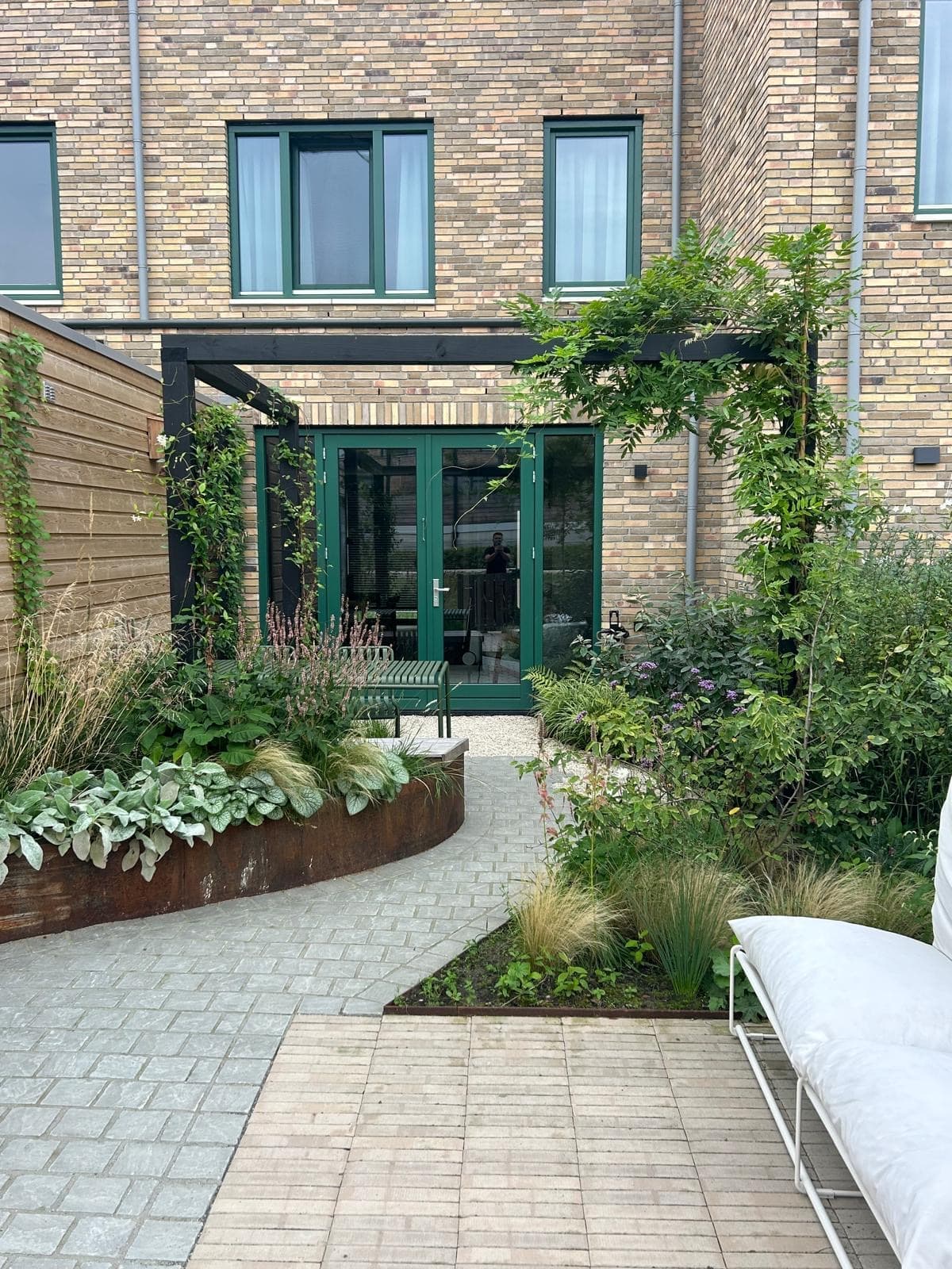 Lush courtyard garden with corten steel borders and clinker path
