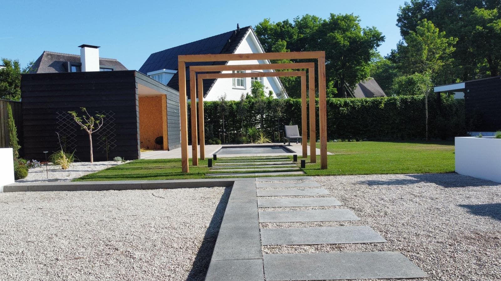 Wooden pergolas above stepping stones leading to the pool