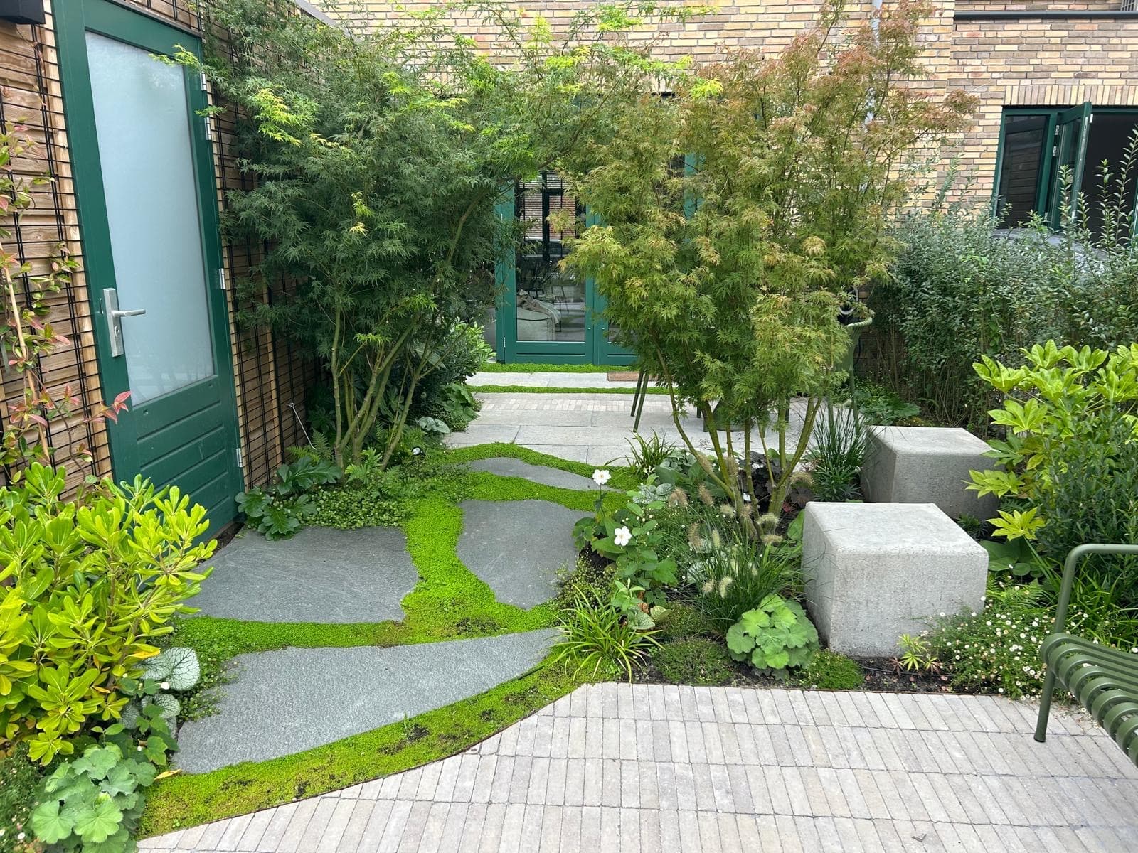 Tuinontwerp met grind, klinkers en weelderige borders, luchtfoto