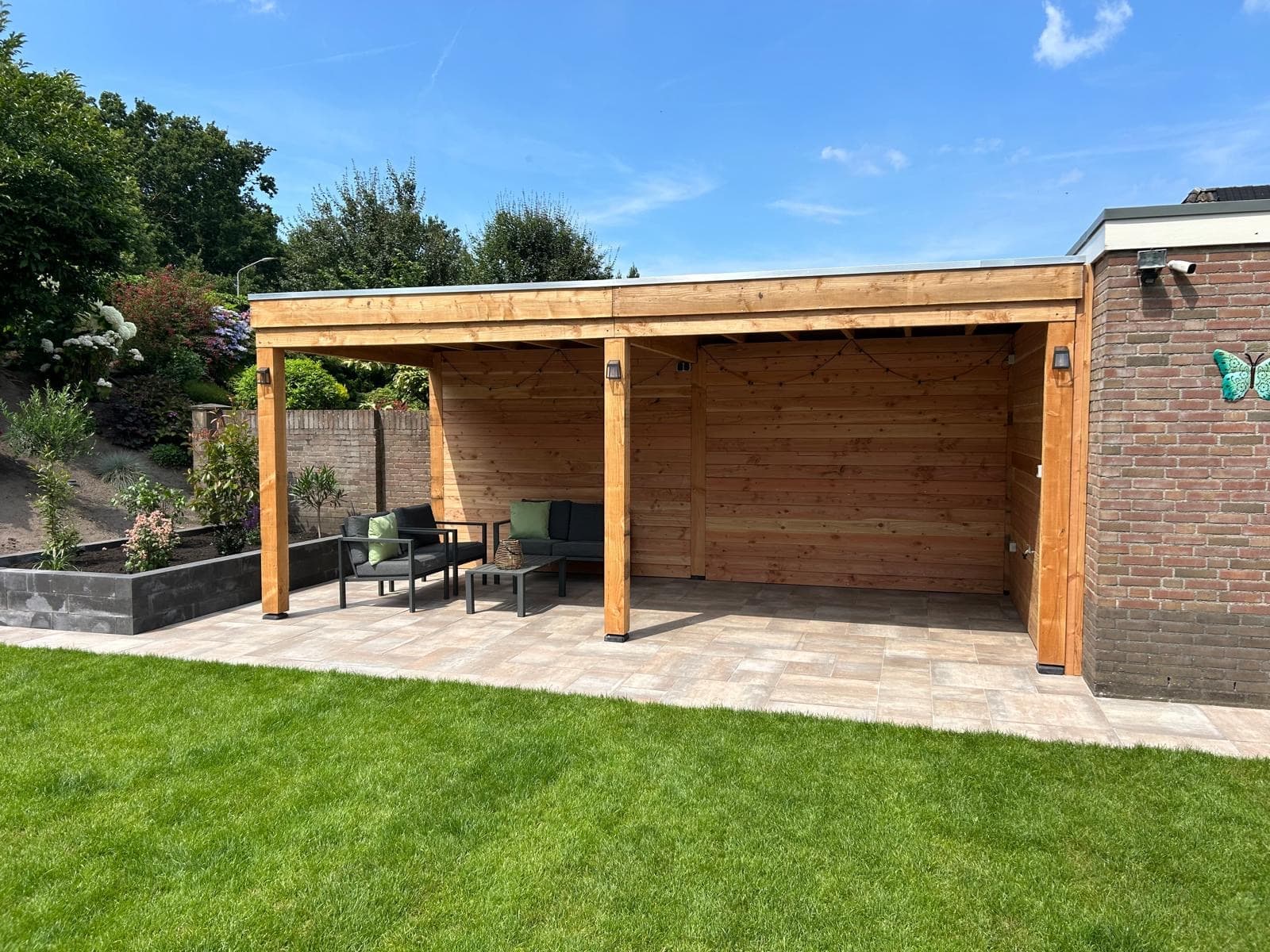 Wooden canopy with lounge set, ceramic patio and neat lawn