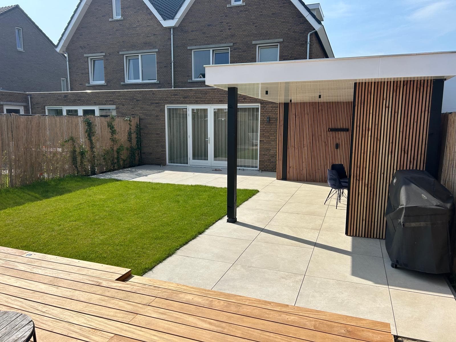 Modern white canopy with wooden slat wall and light patio