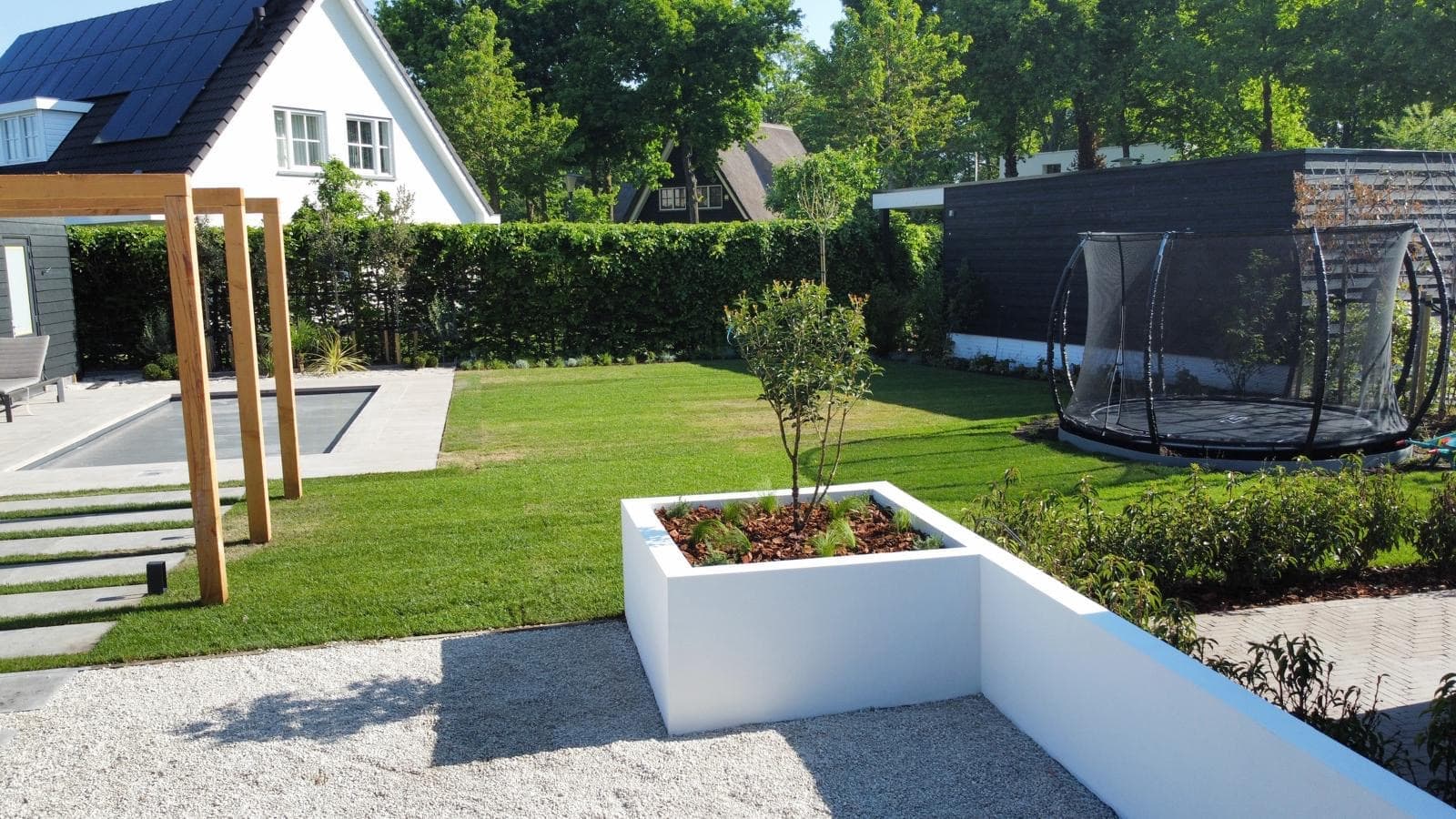 Luxe tuin met zwembad, pergola en strak gazon