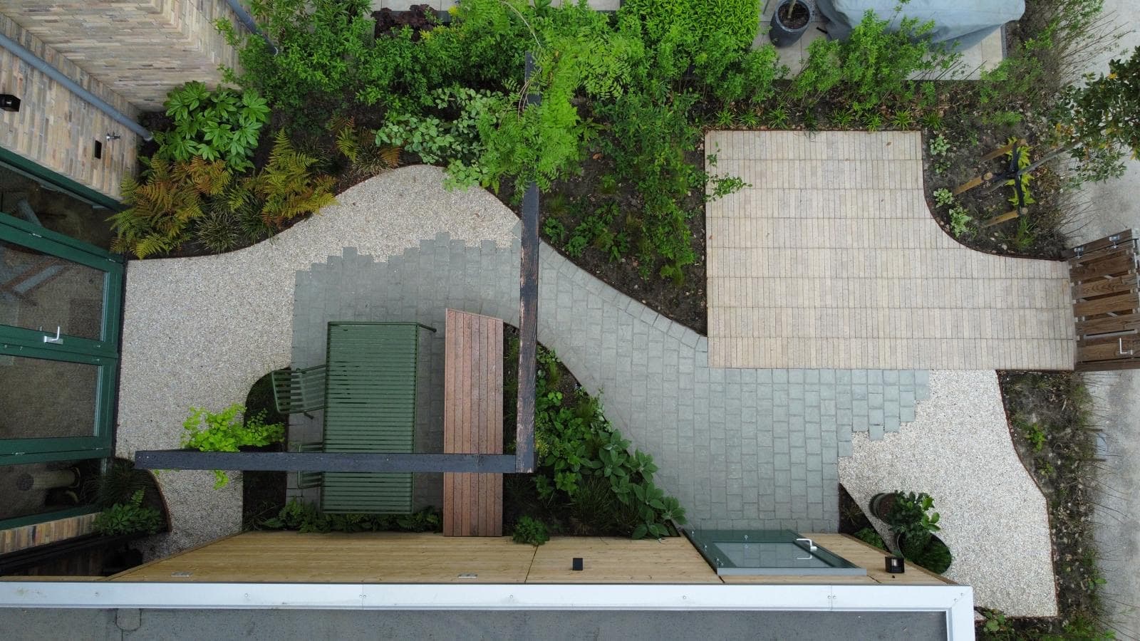 Tuinontwerp met grind, klinkers en weelderige borders, luchtfoto