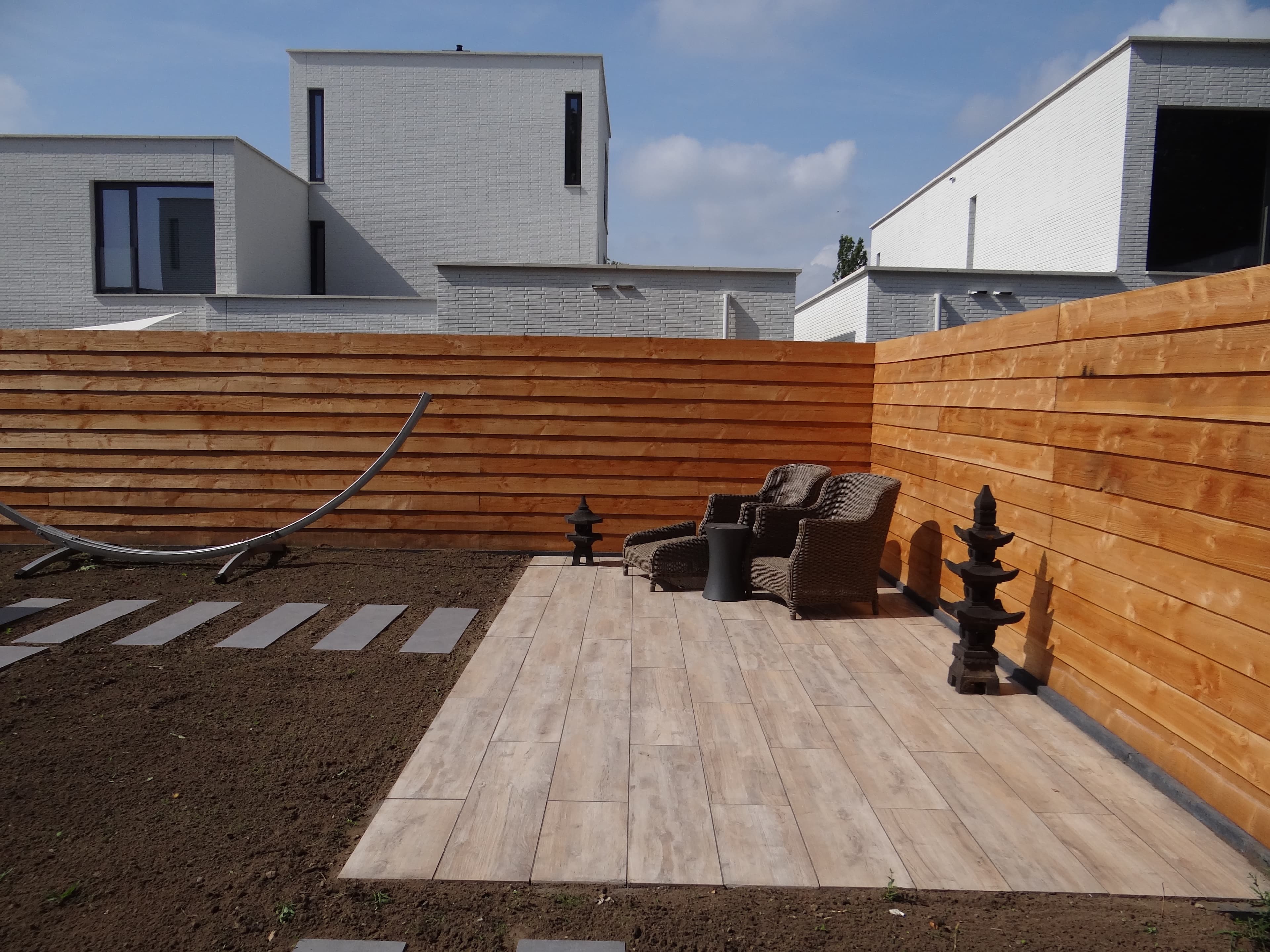 Horizontal larch fence around a patio with lounge chairs and pagoda lanterns